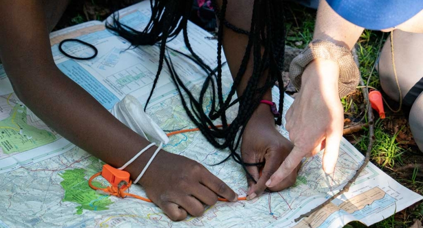 two people point out a location on a map on an expedition with outward bound